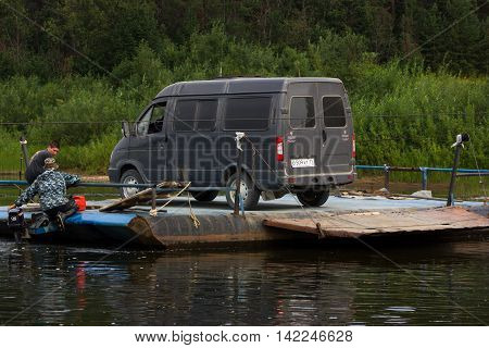 Borovskaya Russia - 22.07.2016: ferryman tranports minibus throw the river on handmade ferryboat