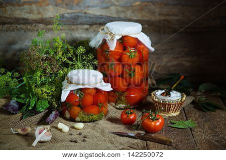A few jars with canning tomatoes and ingredients for conservation. Rusic style