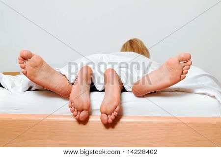 Pieds d'un couple au lit. Amour, sexe et sexe