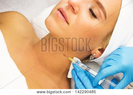 Macro view lying young woman injection hands with medical gloves beauty treatment