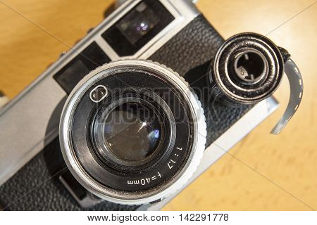 Antique SLR or Reflex camera with film roll over wooden surface