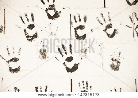 black hand paints over white wall to backgrounds
