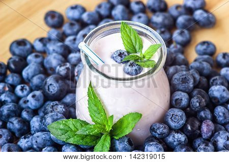 Beautiful appetizer blueberry fruit smoothie milk shake glass jar with juicy fresh berries background top view Yogurt cocktail Natural detox Liquid ice cream hurtleberry huckleberry winberry fraughan