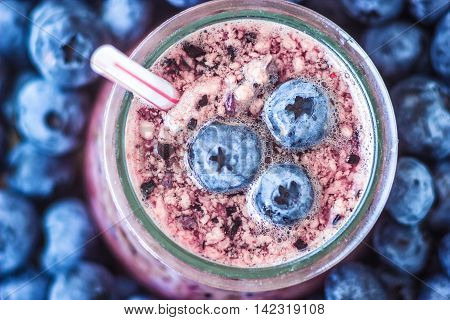 Beautiful appetizer blueberry fruit smoothie milk shake glass jar with juicy fresh berries background top view Yogurt cocktail Natural detox Liquid ice cream hurtleberry huckleberry winberry fraughan