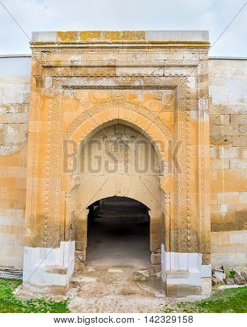 The gate of Agzikarahan Caravan Saray built of bright orange local stone and decorated with carved patterns Cappadocia Turkey.