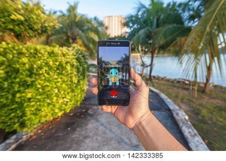 California, United States - July 30, 2016: Close up view of a person hand holding a smartphone and playing Pokémon Go