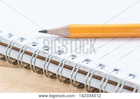 close-up one yellow pencil put on notebook