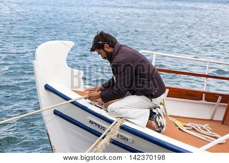 CRETE ISLAND, GREECE - JUNE 23, 2016: A fisherman in traritional wooden fishing boat, Crete island, Greece, June 23, 2016