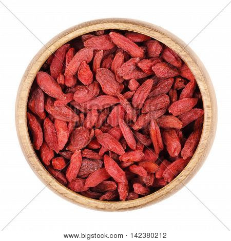 Goji berries in a bowl on white background, also called wolfberry. Dried red fruits and seeds of Lycium barbarum and Lycium chinense. Edible, raw and organic food. Isolated close up macro photo.