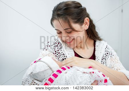 a young mother looks at her newborn daughter