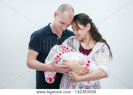 Happy family holding their newborn baby in her arms