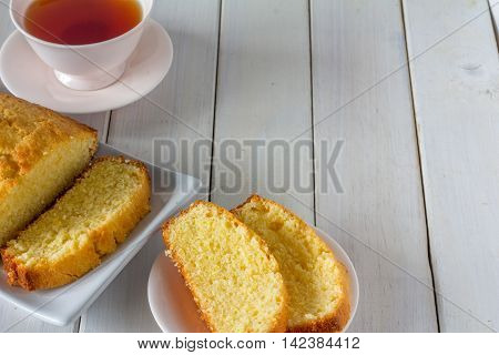 Madeira Cake from Above with Tea on a White Wooden Table with Copy Space Horizontal