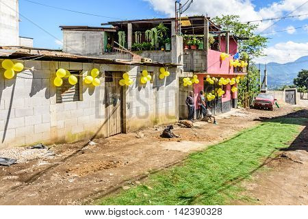 San Juan del Obispo Guatemala - June 26 2016: Houses adorned with balloons & pine needle carpet in street as part of St John's Day celebrations in village named after the patron saint. Near Antigua, a UNESCO World Heritage Site.