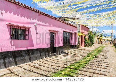 San Juan del Obispo Guatemala - June 26 2016: Houses adorned with balloons & bunting & pine needle carpets in street as part of St John's Day celebrations in village named after the patron saint. Near Antigua, a UNESCO World Heritage Site.