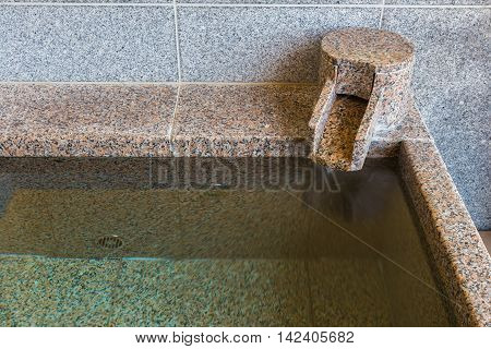 Close up section of onsen marble bathtub and marble faucet Japanese style bath