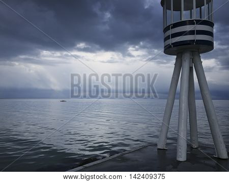 Coastal sculler and beacon seen from the shore