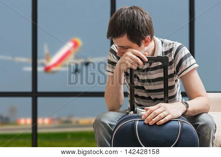 Delayed Aeroplane Concept. Tired Passenger Is Sitting With Bagga