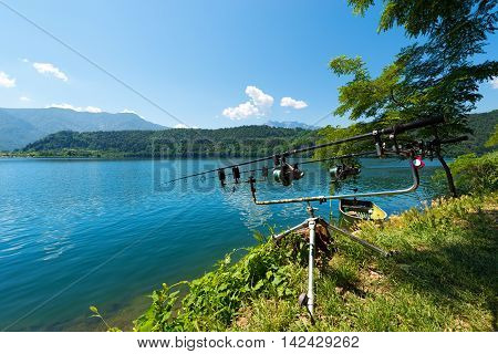Two fishing rods with reels on a support system (rod pod) at Levico Lake (Lago di Levico) in Trentino Alto Adige Italy Europe