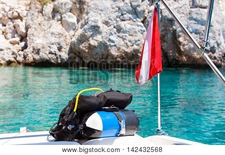 Divers flag with scuba diving equipment laying on a boat