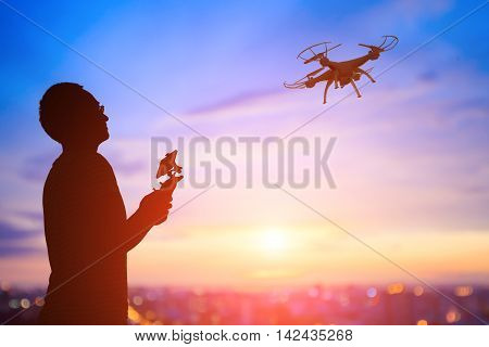 silhouette of man play drone in the sunset asian