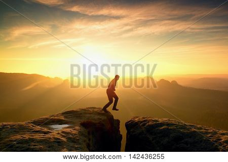 Silhouette Of Jumping Man And Beautiful Sunset Sky. Vintage Effect