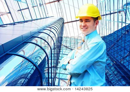 Giovane architetto indossando una standing casco protettivo sullo sfondo edificio