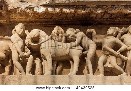Intimate life of ancient people on stone relief on wall of Khajuraho temple India. UNESCO Heritage site built between 950 and 1150 in India belong to Hinduism and Jainism.