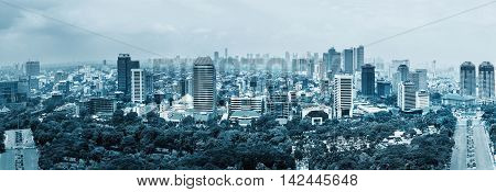 Aerial panoramic view of Jakarta, capital of Indonesia. Panorama of Jakarta skyscrapers at cloudy day, blue colored