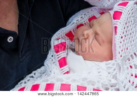 newborn baby sleeping on father's hands. Outdoor
