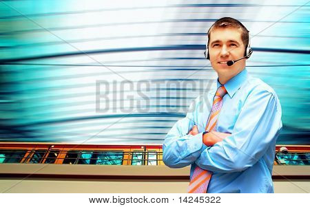 Homme d'affaires de bonheur en headphoness sur le fond d'architecture d'entreprise