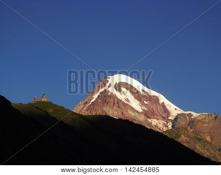 Gergeti Monastery on Mount Kazbek background at sunrise