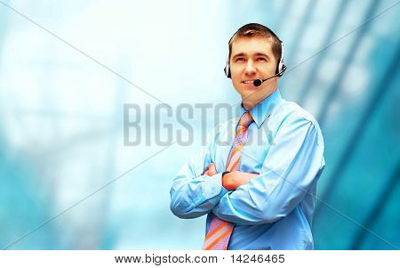 Homme d'affaires de bonheur en headphoness sur le fond d'architecture d'entreprise