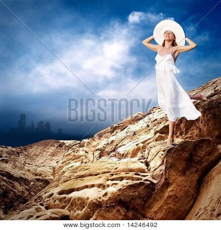 Beautiful girl in White on the mauntain under sky with clouds