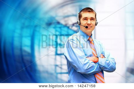 Homme d'affaires de bonheur en headphoness sur le fond d'architecture d'entreprise