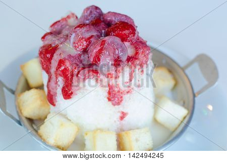 Shaved ice strawberry sauce and toast on white plate