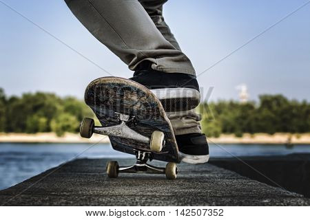 Close up of a skateboarders feet while skating on concrete