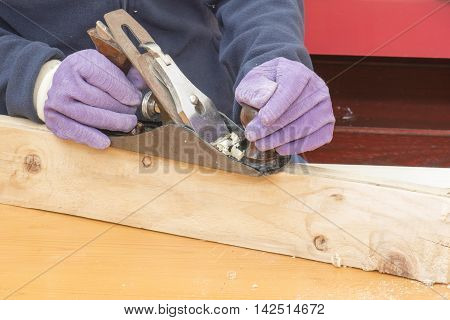 person working, Hands of a carpenter planed wood, on a piece of wood at work in the worksho