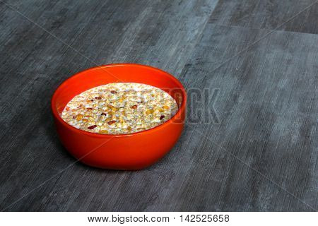 An orange bowl with milk and high protein cereals