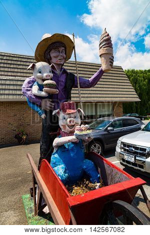 Ronks PA - July 23 2016: Katies is an Amish-owned and operated restaurant that includes a statue of an Amish boy holding an ice cream cone and two pigs.
