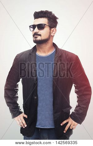 Handsome fashion man smiling and wearing sunglasses jacket. isolated on white