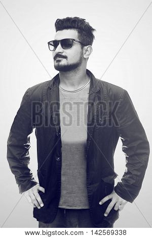 Handsome fashion man smiling and wearing sunglasses jacket. isolated on white