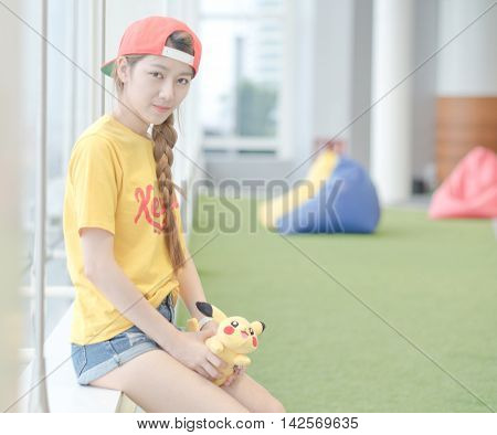 BANGKOK THAILAND – August 142016: Trainer girl playing pokemon pokemon ball Lighting with sun flare