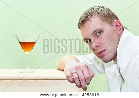 Pohledný muž sedí s sklenky alkoholu. Kavkazská Gay