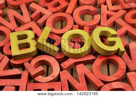 Word Blog made of green wooden block letters over the pile of red ones