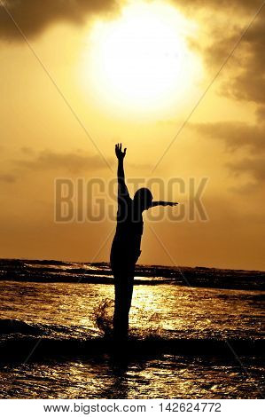 SIlhouette of a man jumping against setting sun on karacchi beach clifton Pakistan