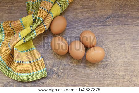 Five raw eggs on a wooden table background top view.
