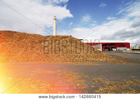 Bio Power Plant With Storage Of Wooden Fuel Against Blue Sky