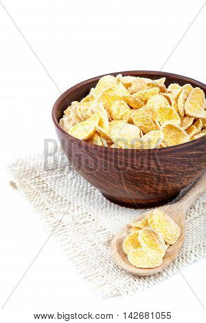 Cornflakes in a wooden bowl isolated on white background.