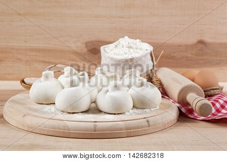 Baking ingredients for cooking manti dumplings on a wooden board.