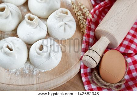 Baking ingredients for cooking manti dumplings on a wooden board.